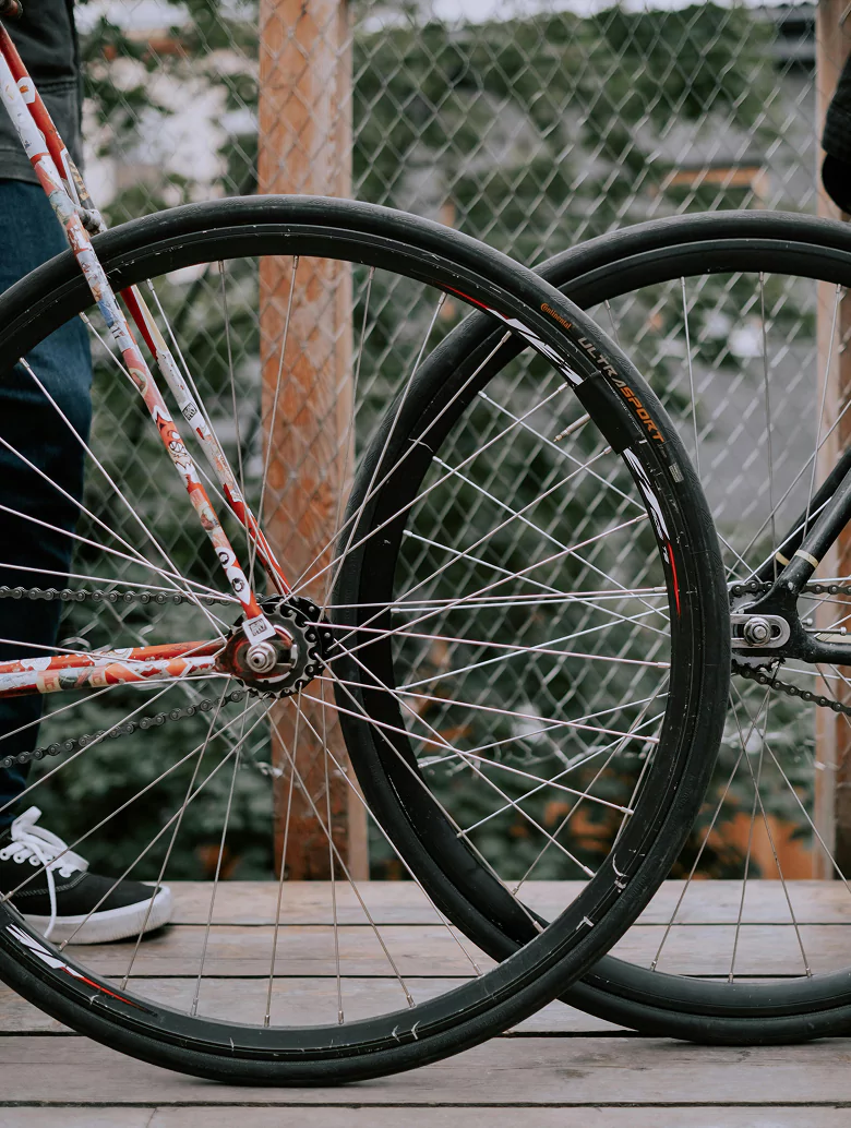 Two bicycles parked side by side on a paved surface