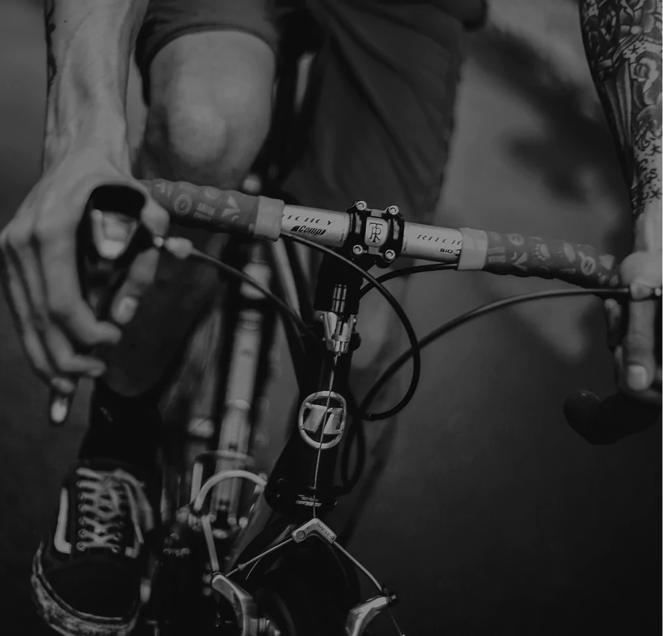 A black and white photo of a man riding a bicycle on a street.