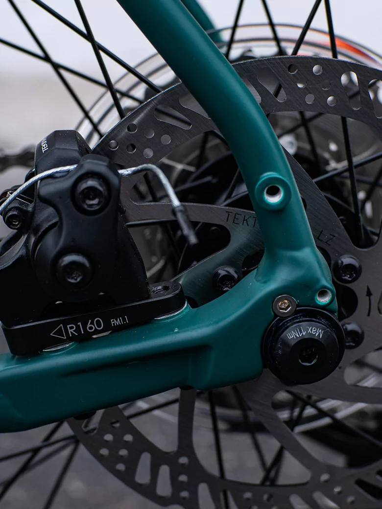 Close-up of the front brake on a bicycle, illustrating the parts involved in the braking process.
